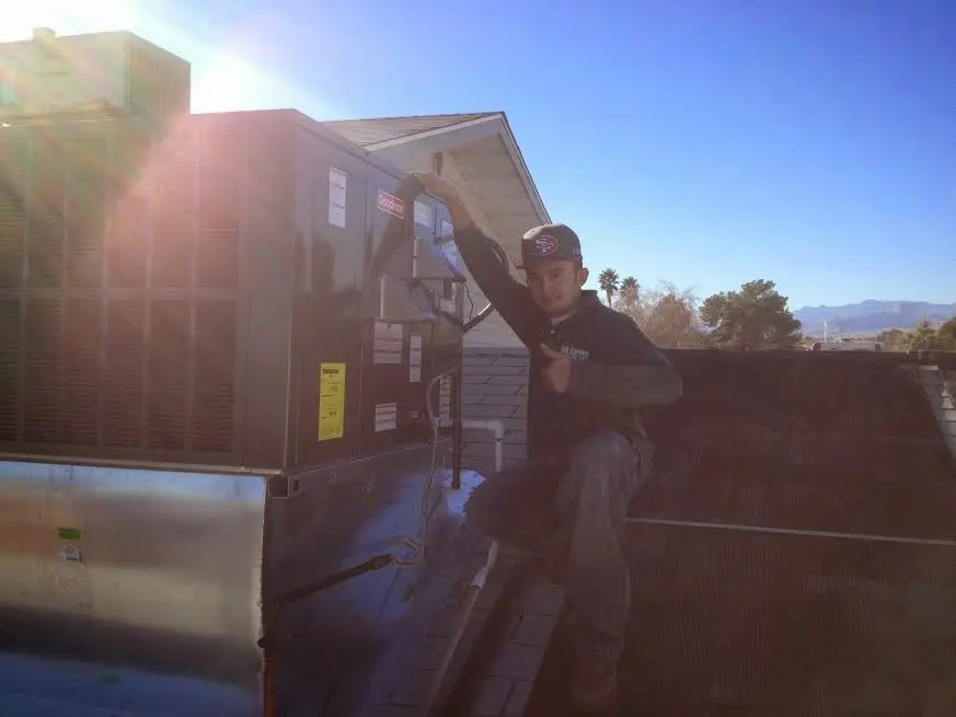 HVAC technician performing Air Duct Repair on a rooftop unit in Wesley Chapel